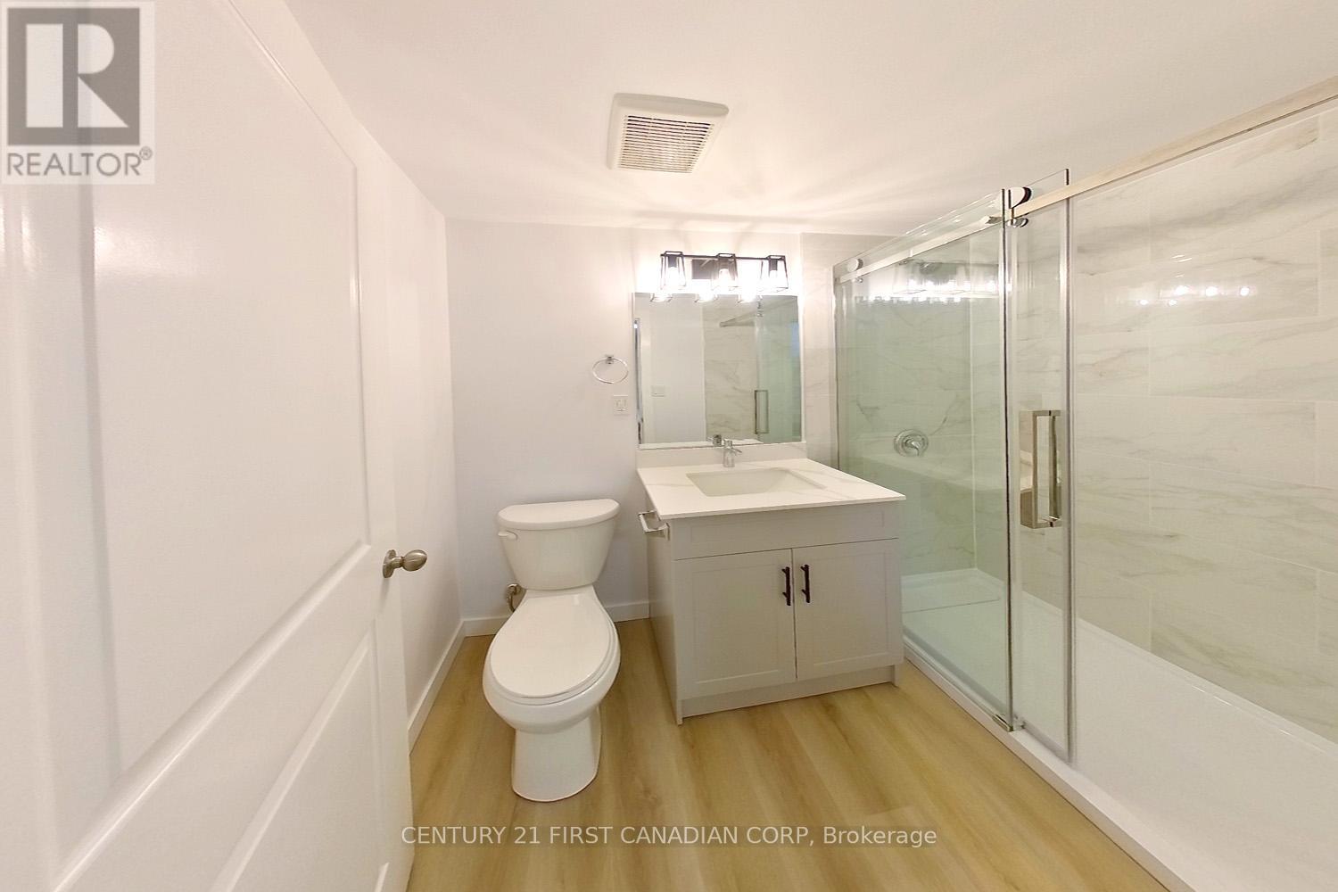 A white toilet sits next to a sink in a small bathroom.