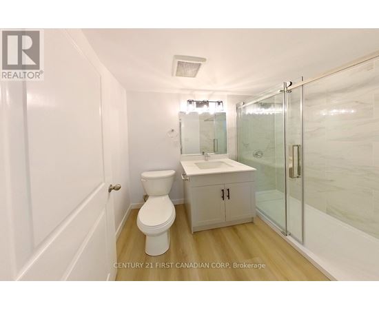 A white toilet sits next to a sink in a small bathroom.