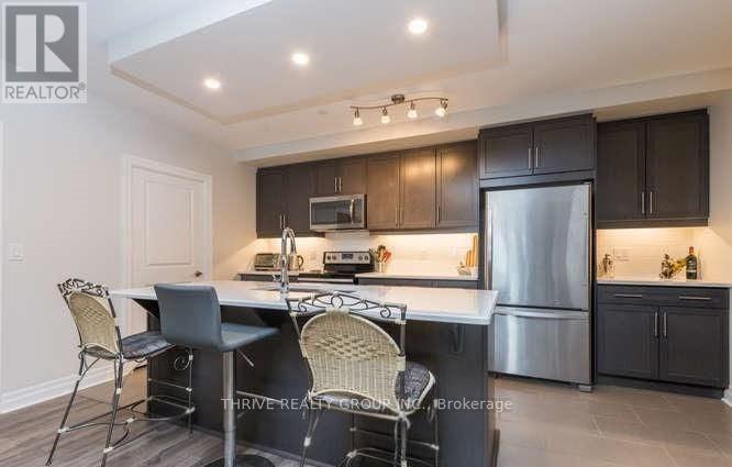 A kitchen with a table and chairs in front of a refrigerator.
