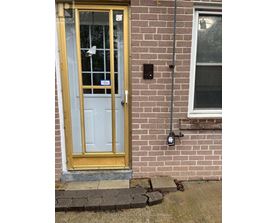 A yellow door with a glass window and a sign on it.