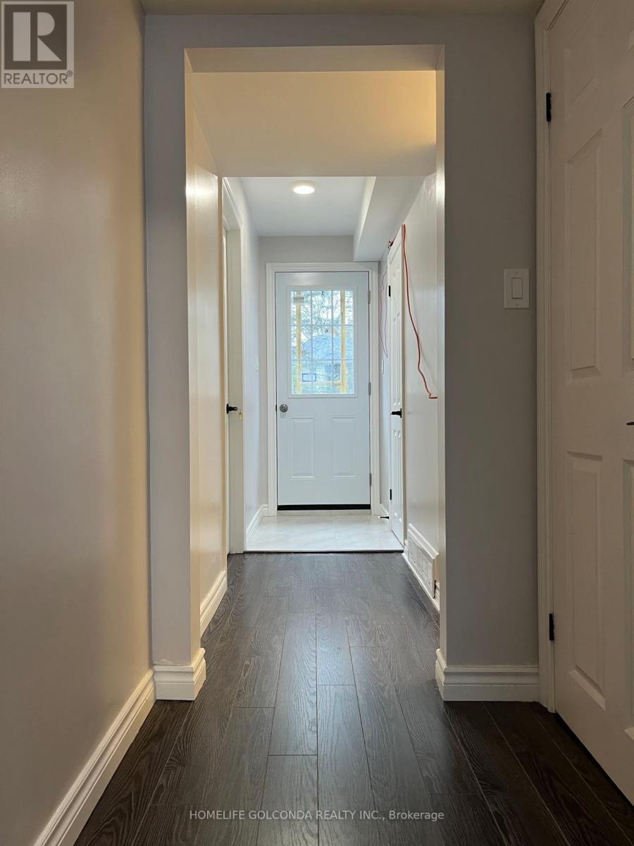 A hallway with a white door and a wooden floor.