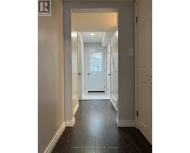 A hallway with a white door and a wooden floor.