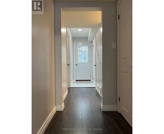 A hallway with a white door and a wooden floor.