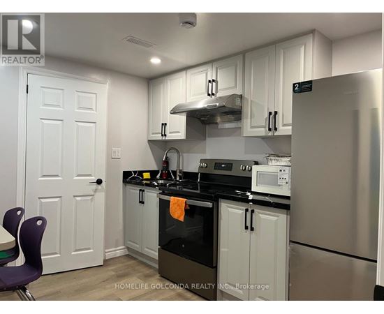 A kitchen with white cabinets and a black stove top.