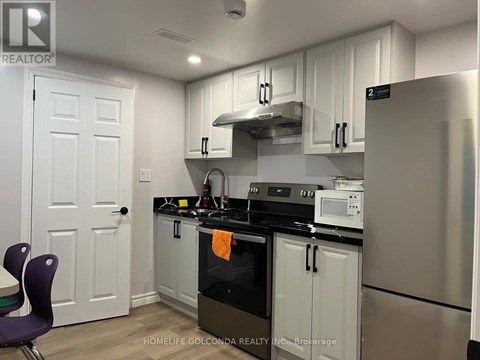 A kitchen with white cabinets and a black stove top.