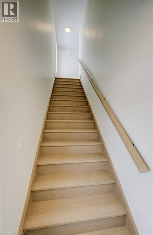 A wooden staircase with a white wall on the side.