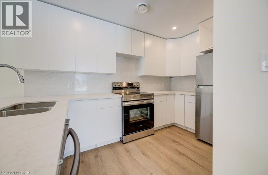 A modern kitchen with white cabinets and stainless steel appliances.