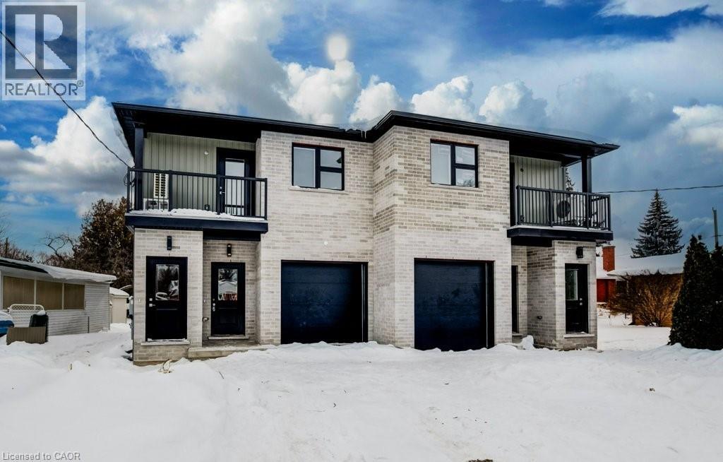 A two-story house with a balcony on the second floor is surrounded by snow.