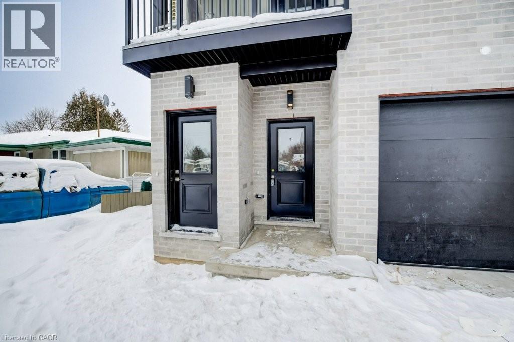 A house with a black door and a window is surrounded by snow.