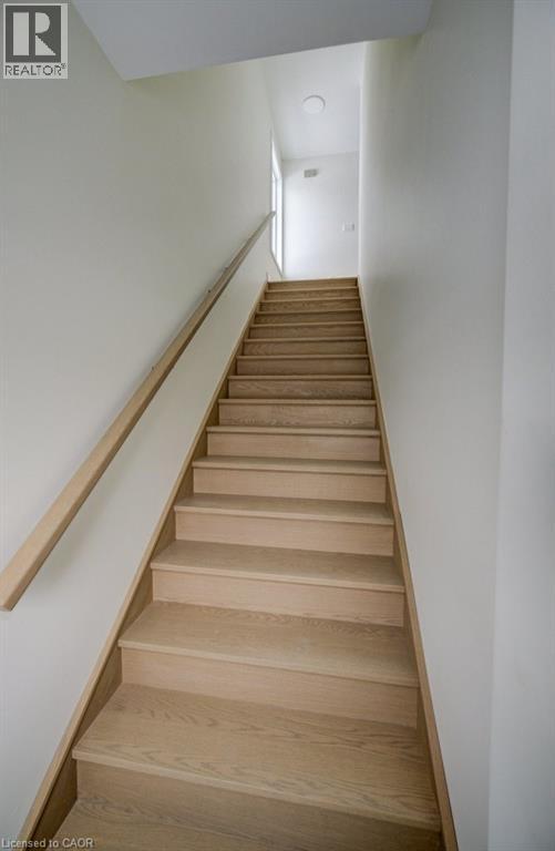 A long flight of wooden stairs leads to a door at the end.