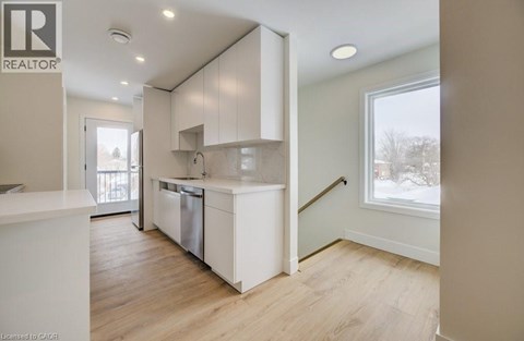 A kitchen with white cabinets and a dishwasher.