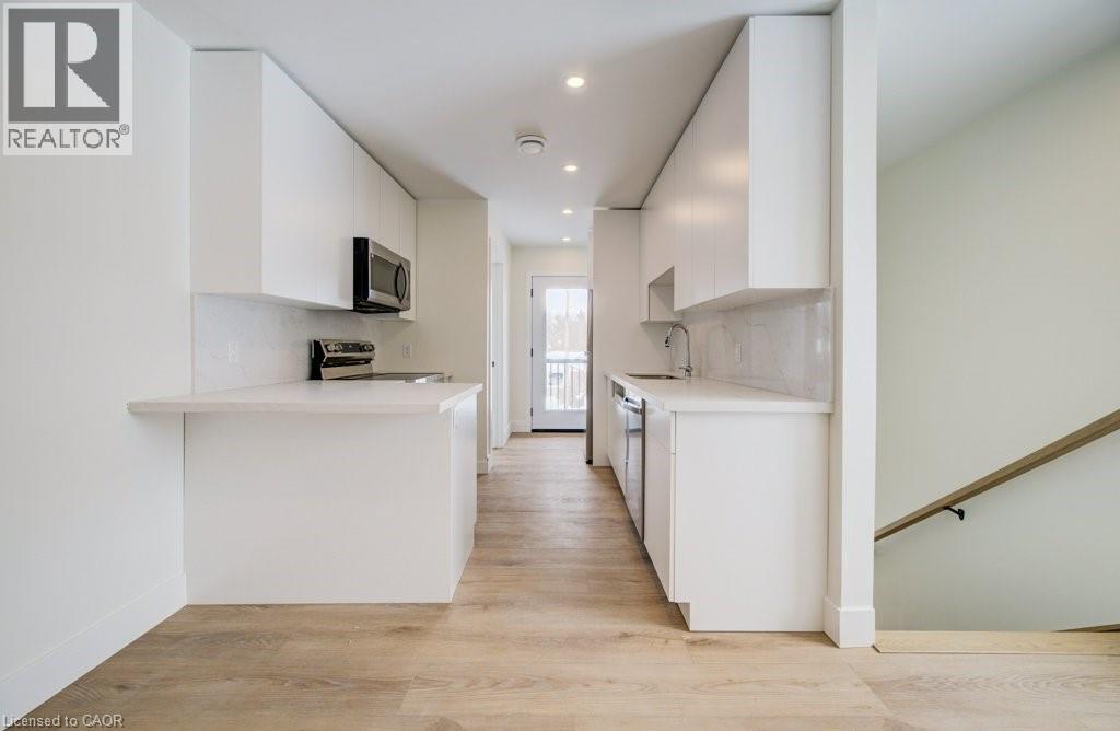 A white kitchen with a microwave on the counter.