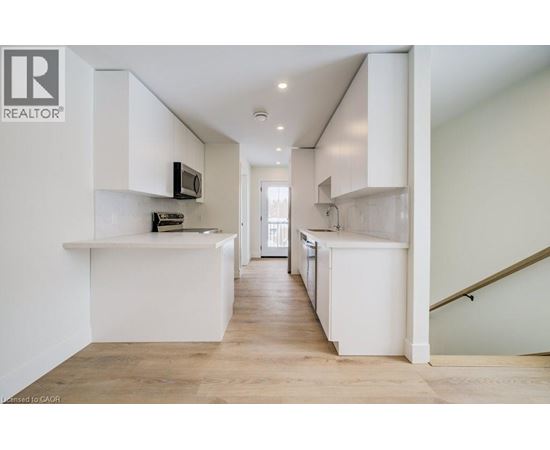 A white kitchen with a microwave on the counter.