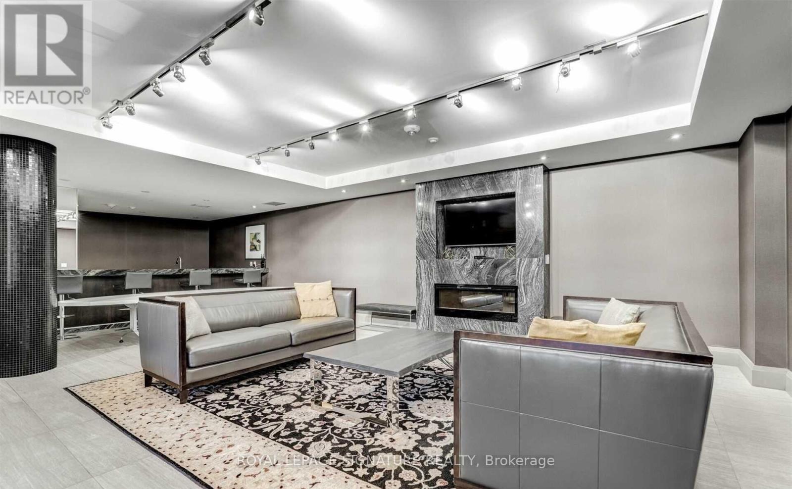 A modern living room with a grey sofa and a fireplace.
