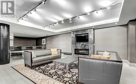 A modern living room with a grey sofa and a fireplace.