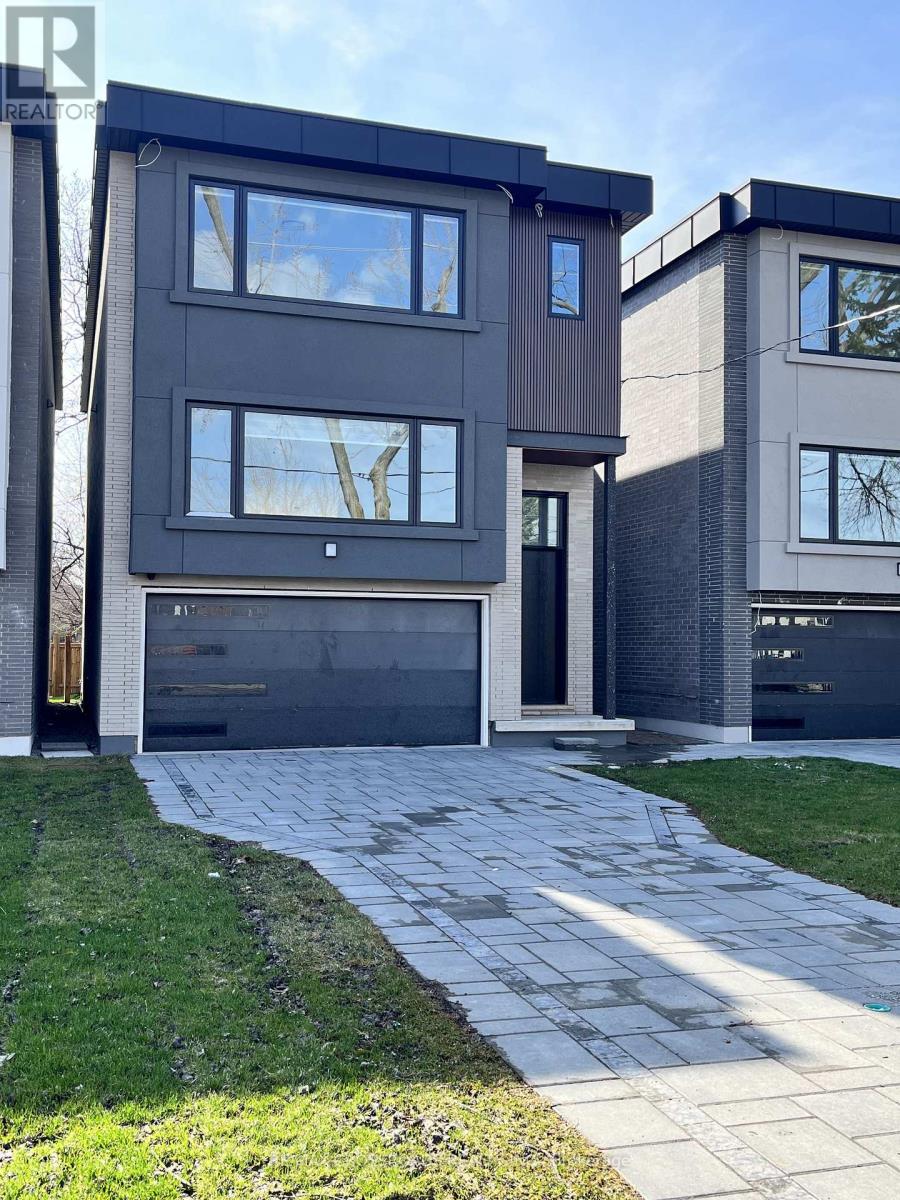 A modern house with a grey facade and a black garage door.