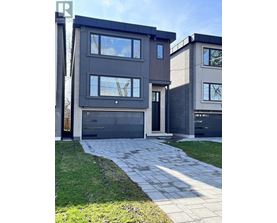 A modern house with a grey facade and a black garage door.