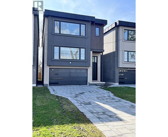 A modern house with a grey facade and a black garage door.