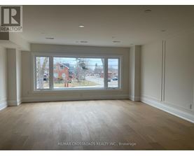 A room with a large window and wooden flooring.