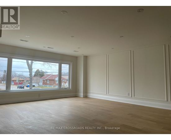 A room with a large window and wooden flooring.