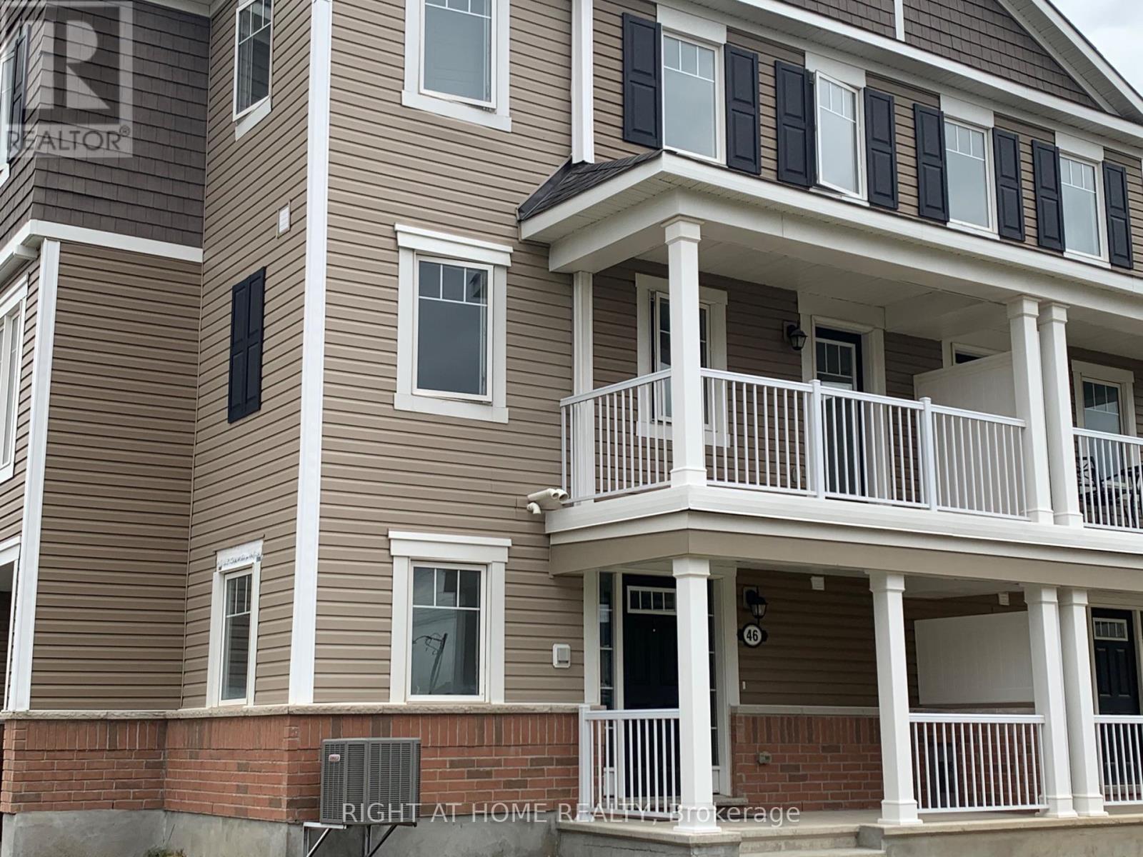 A two-story house with a balcony and a brick foundation.