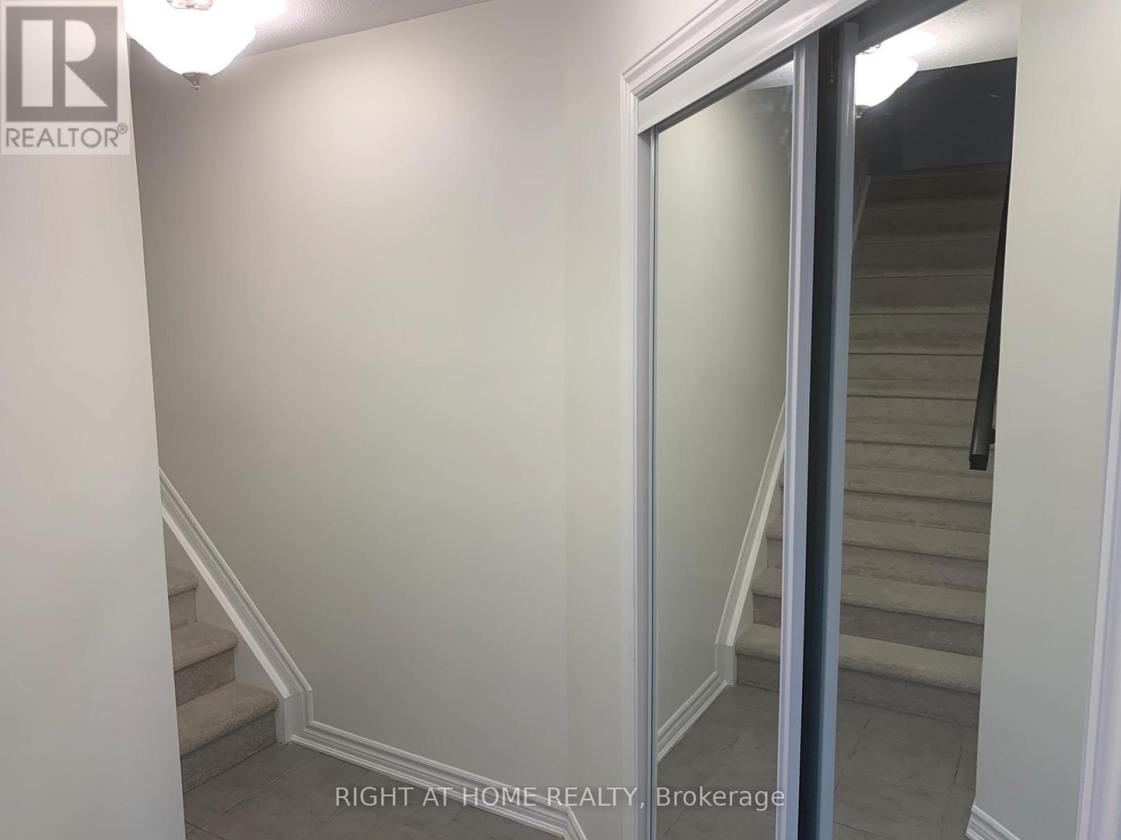 A hallway with a staircase and a glass door.