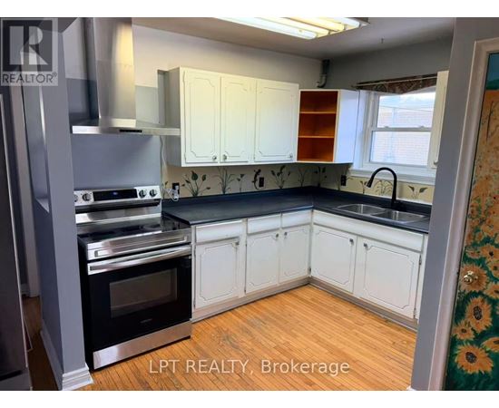 A kitchen with white cabinets and a black countertop.
