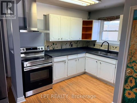 A kitchen with white cabinets and a black countertop.