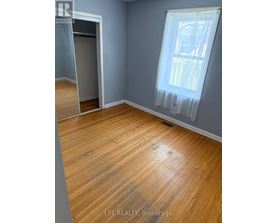 A room with wooden flooring and a window with curtains.