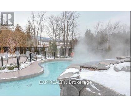 A hot tub in a snowy landscape with steam rising from it.