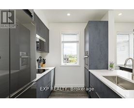A modern kitchen with dark grey cabinets and a large window.