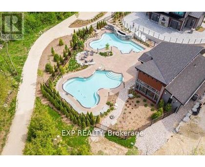 A brokerage sign is displayed on an aerial view of a property with a swimming pool.