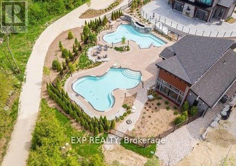 A brokerage sign is displayed on an aerial view of a property with a swimming pool.
