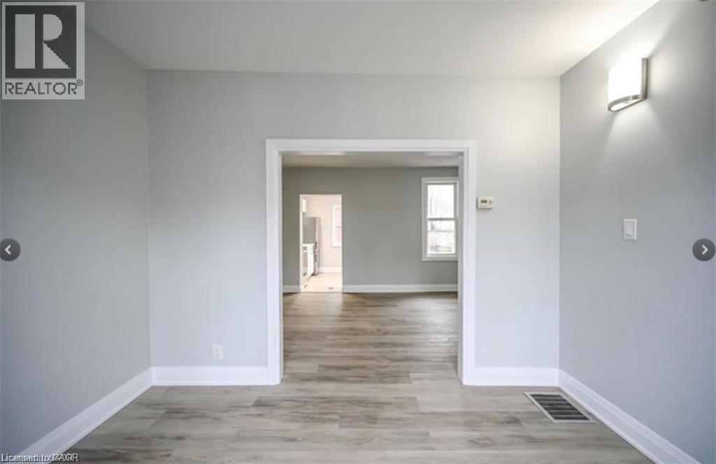 A realtor's image of a room with a doorway leading to another room.