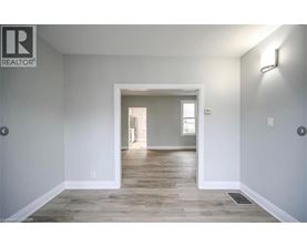 A realtor's image of a room with a doorway leading to another room.