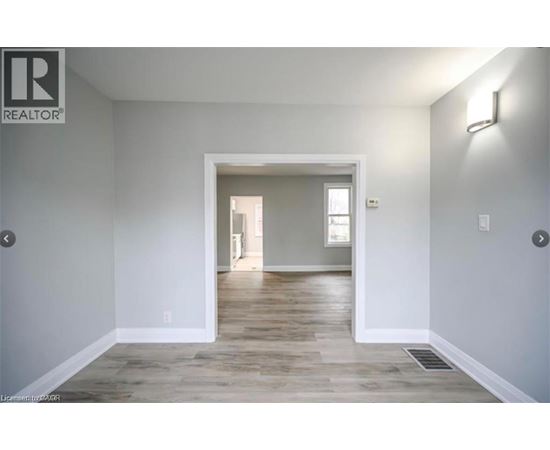 A realtor's image of a room with a doorway leading to another room.