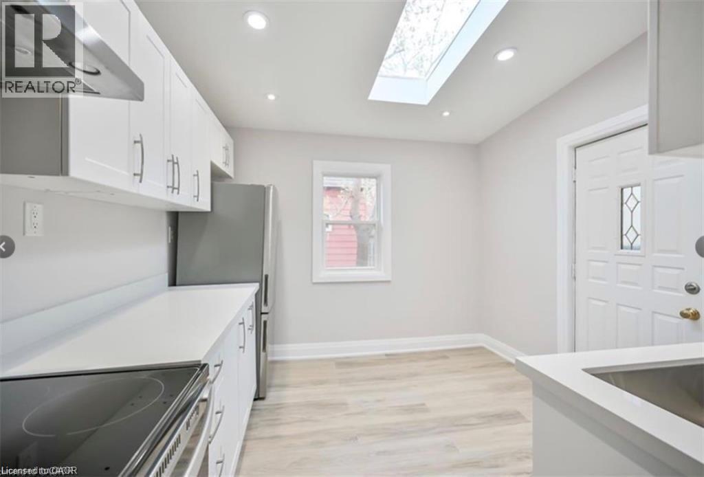 A kitchen with white cabinets and a stove top oven.