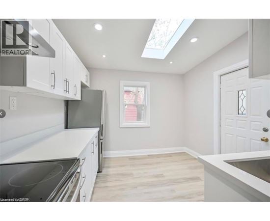 A kitchen with white cabinets and a stove top oven.