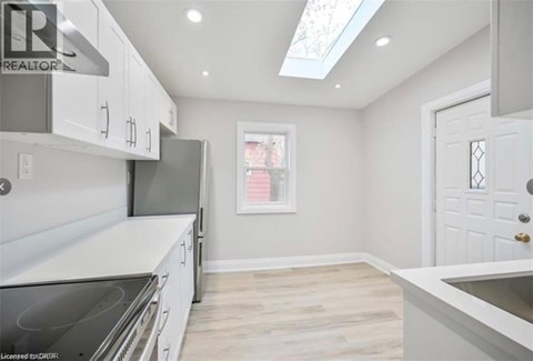 A kitchen with white cabinets and a stove top oven.