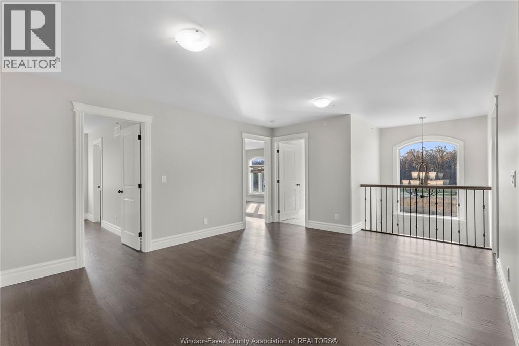 A spacious room with wooden floors and white walls.