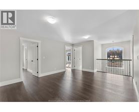 A spacious room with wooden floors and white walls.