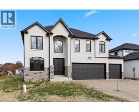 A large, two-story house with a garage is for sale.