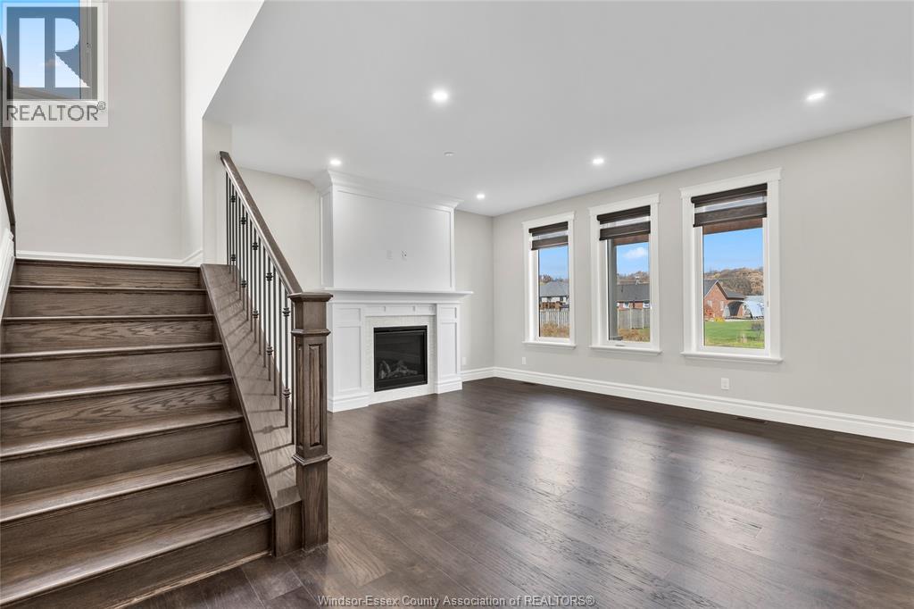 A spacious living room with a staircase leading to the upper floor.
