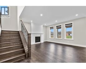 A spacious living room with a staircase leading to the upper floor.