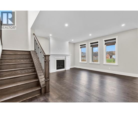 A spacious living room with a staircase leading to the upper floor.