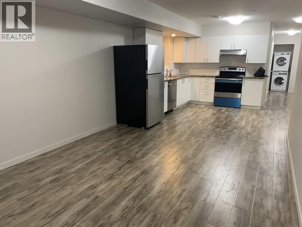 A kitchen with a black fridge, stove, and dishwasher.