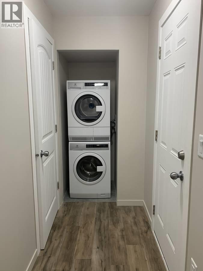 A small laundry room with a washer and dryer stacked on top of each other.