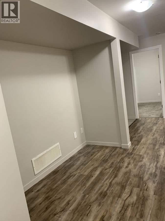 A room with wood flooring and white walls.