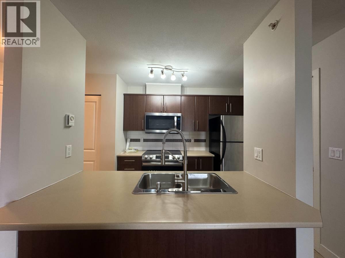 A kitchen with a sink and a refrigerator.