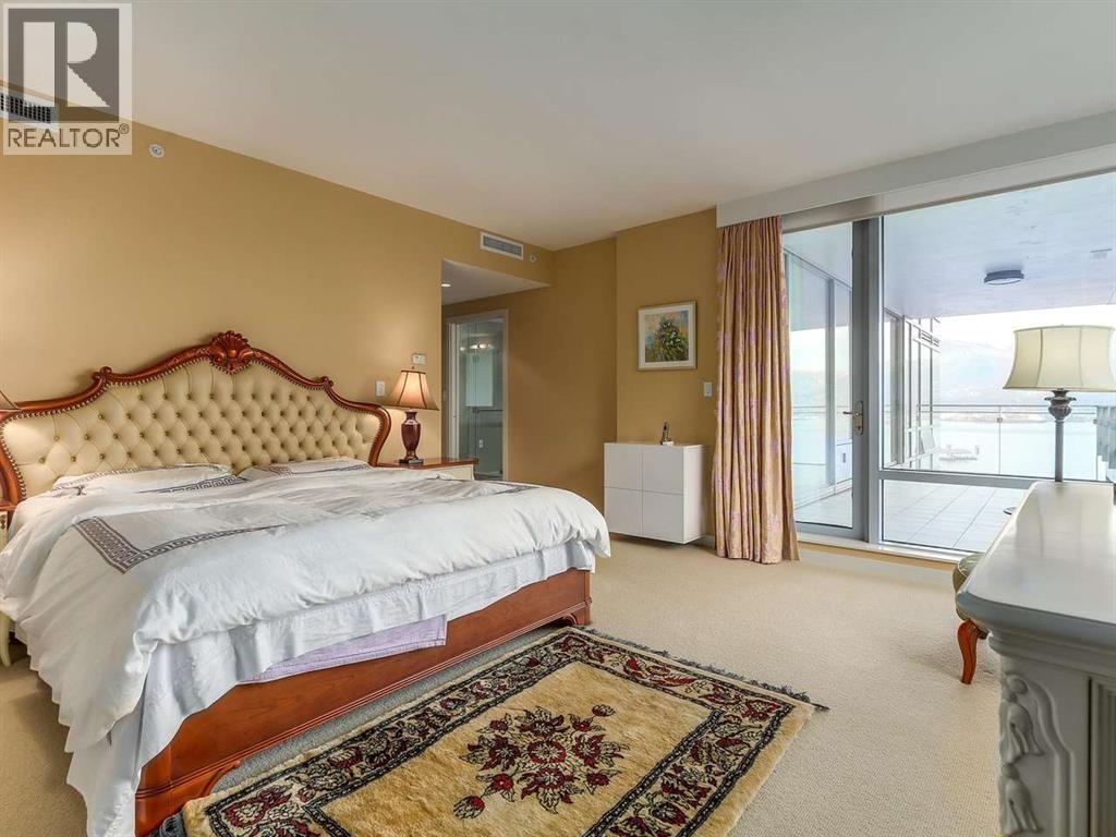A bedroom with a large bed and a rug on the floor.